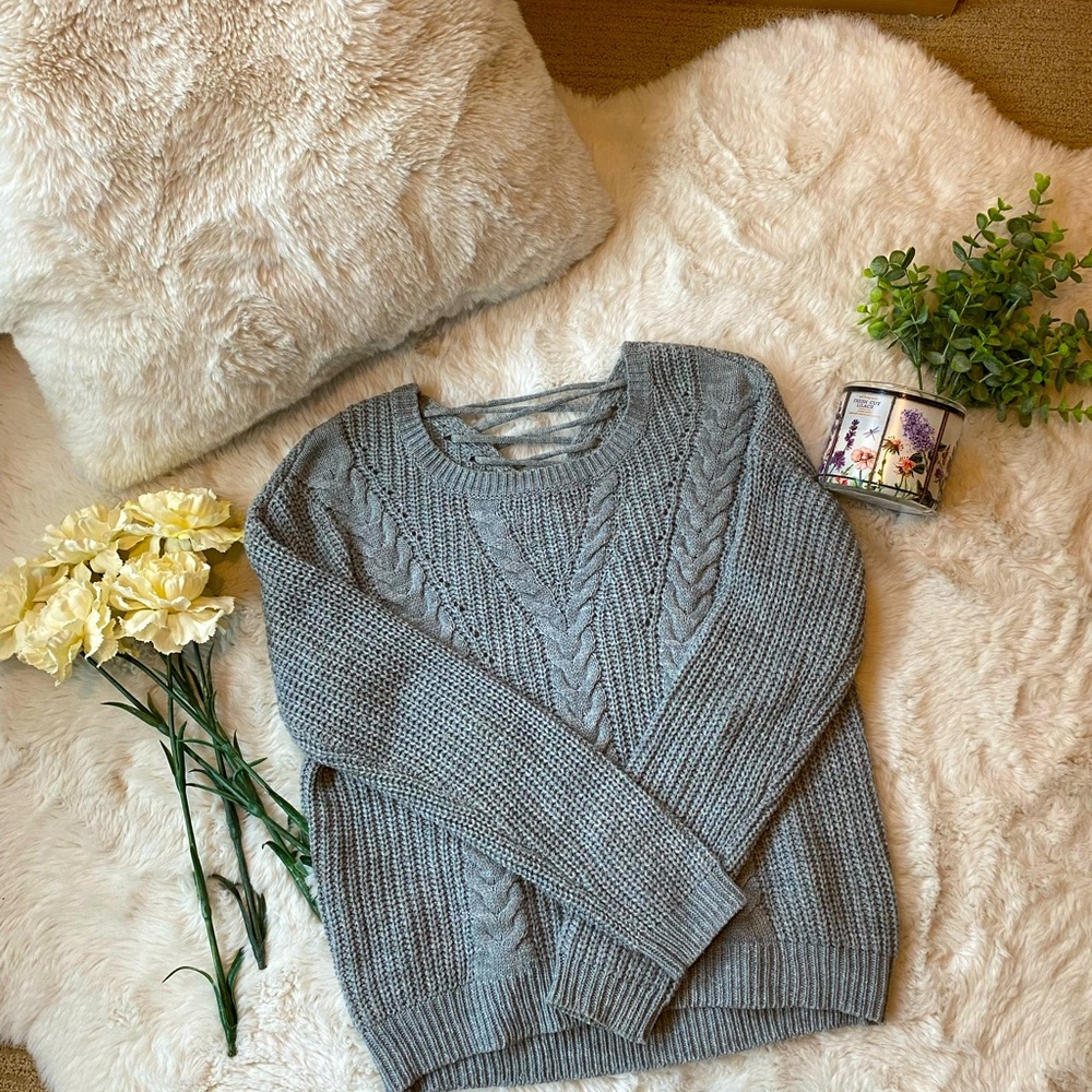 Grey knit sweater with slight drawstring back in women’s small.